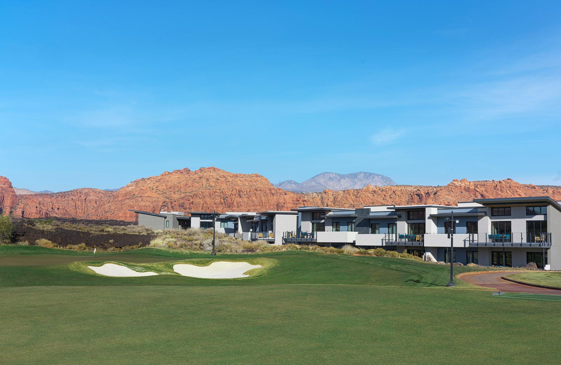 A pristine view of the championship golf course at Black Desert Resort, with luxury villas lining the fairway against a stunning backdrop of Utah's red rock mountains.