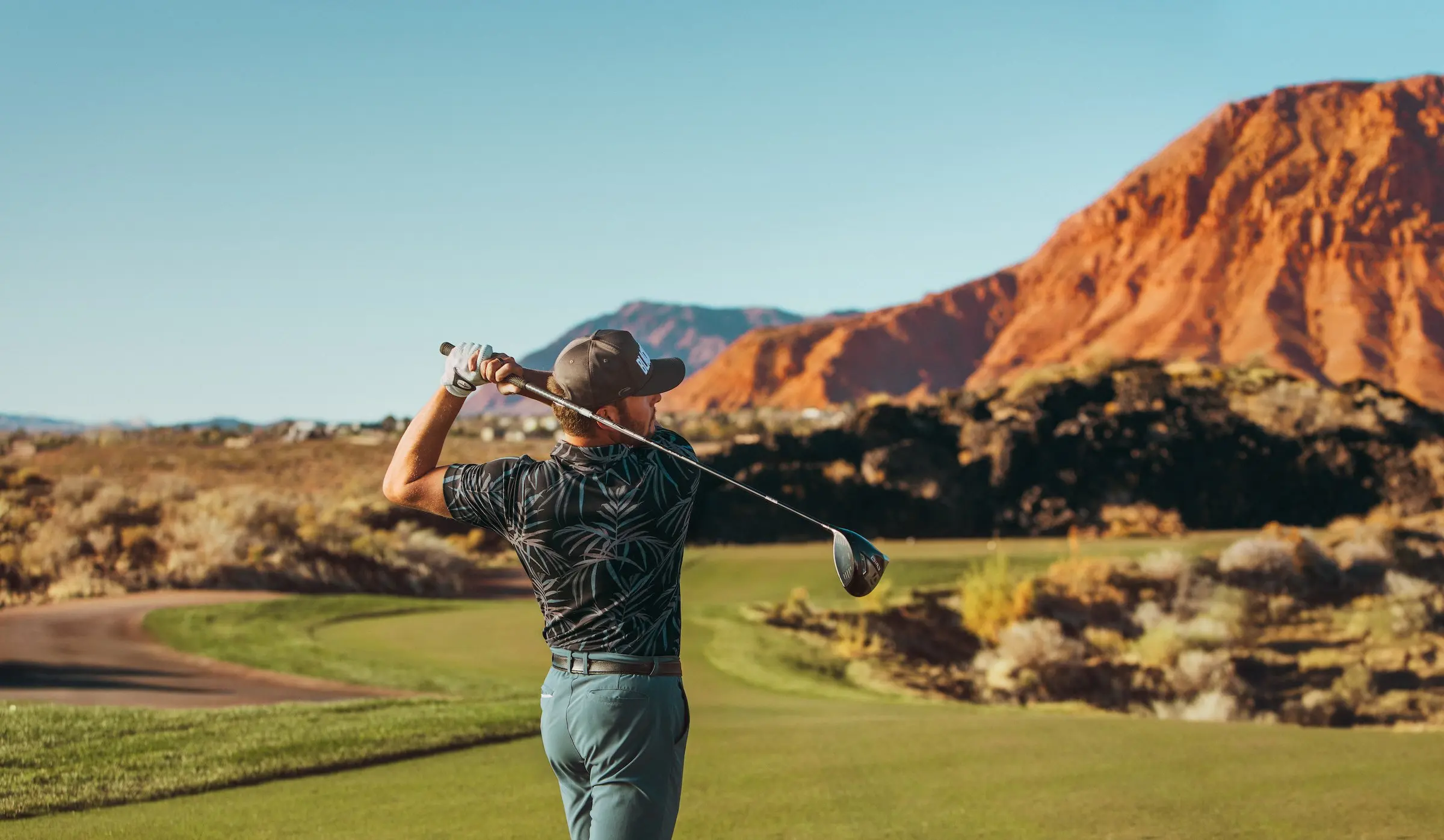 A man in an after golf swing position looking at where the ball went at Black Desert Resort